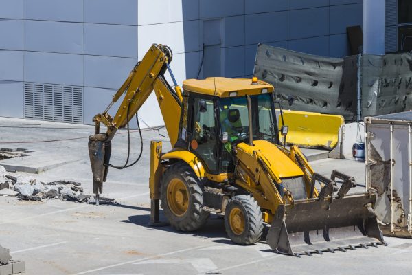 Excavator drilling a street with his jackhammer